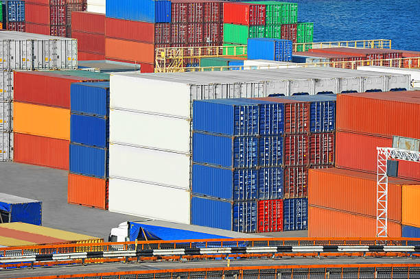 An image of colorful stacked shipping containers at a port.