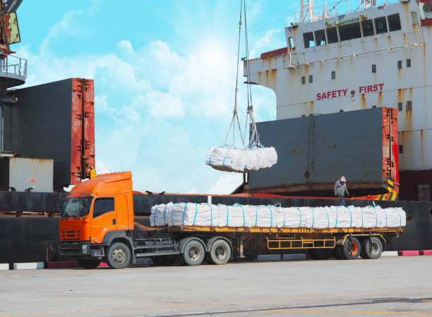 Cargo ship unloading freight to truck showing break bulk vs cross docking process.